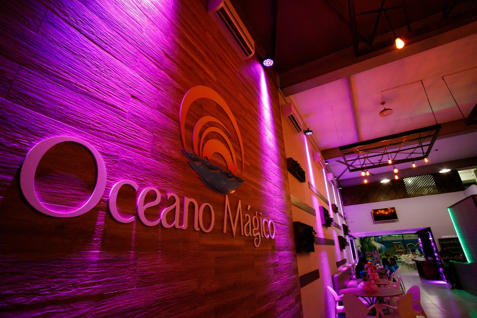 Entrada do Buffet Oceano Mágico com a marca na parede, salão de festas infantis em Guarujá
