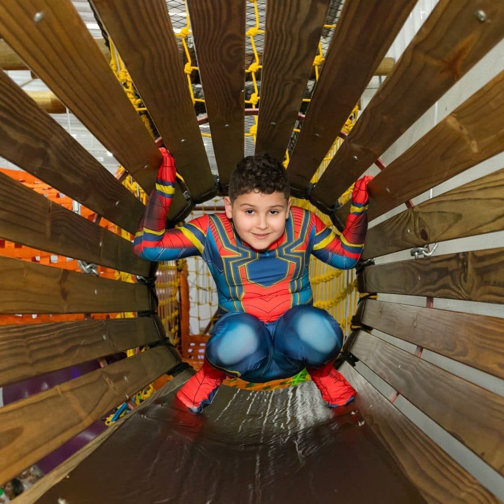 Criança brincando no túnel giratório do Buffet Oceano Mágico, buffet infantil em Guarujá