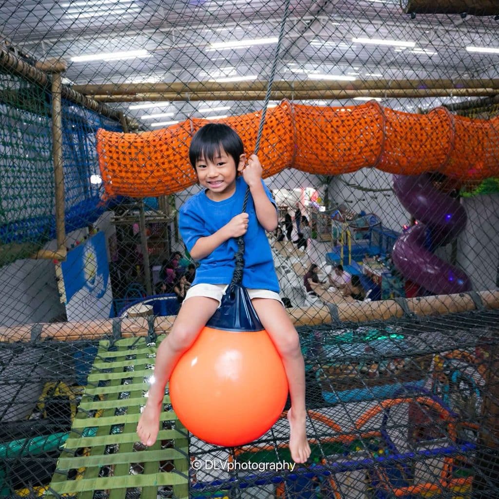 Menino no circuito de obstáculos do brinquedão em Guarujá