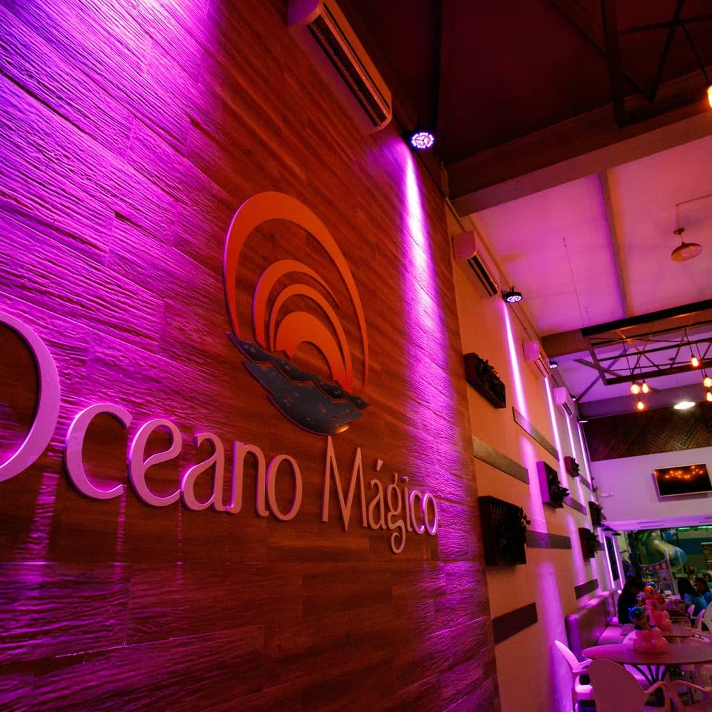 Entrada do Buffet Oceano Mágico com a marca na parede, salão de festas em Guarujá